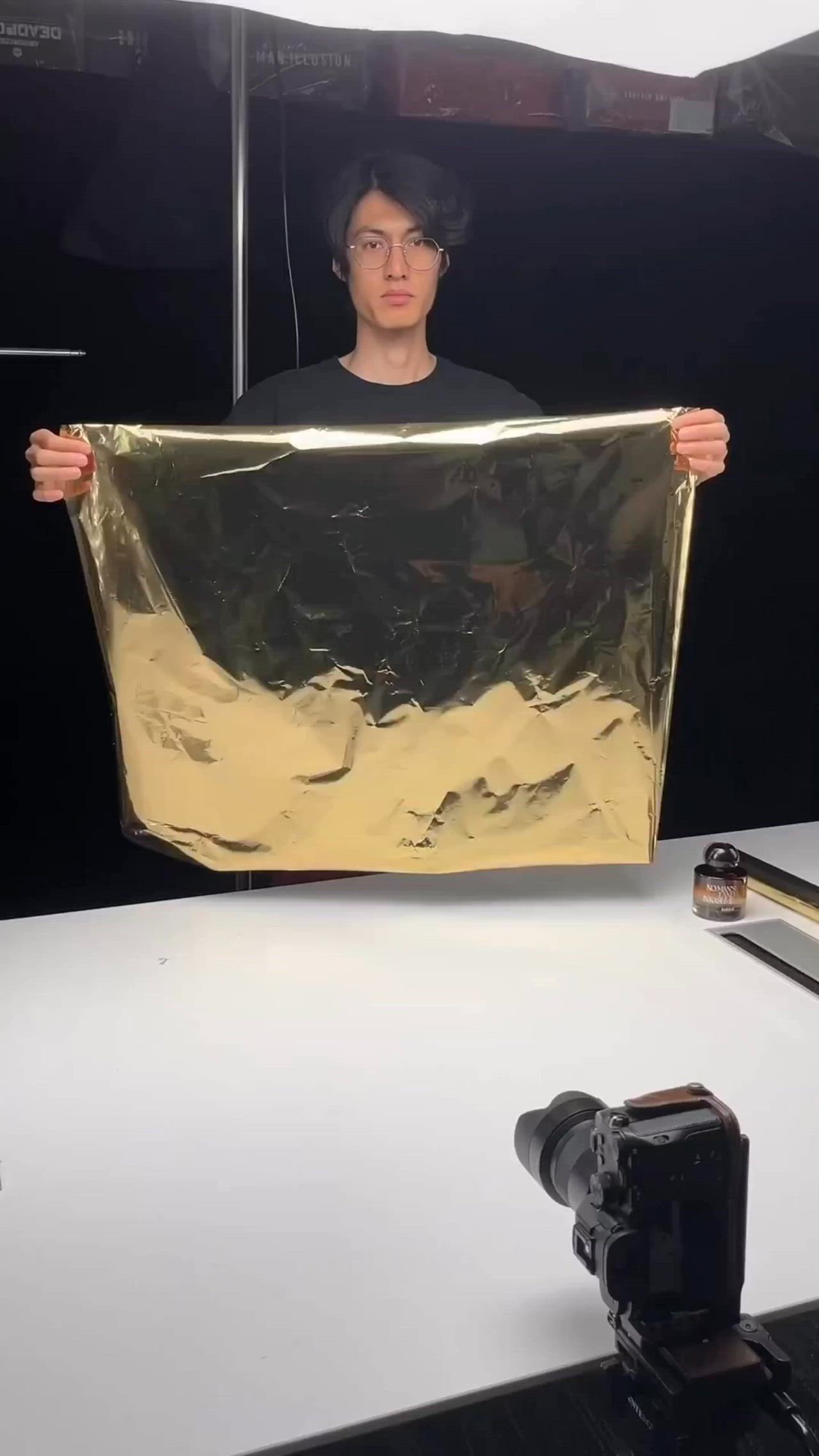 This may contain: a man is holding up a gold foil sheet