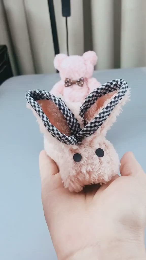 This may contain: a hand holding a small stuffed animal in the shape of a bunny