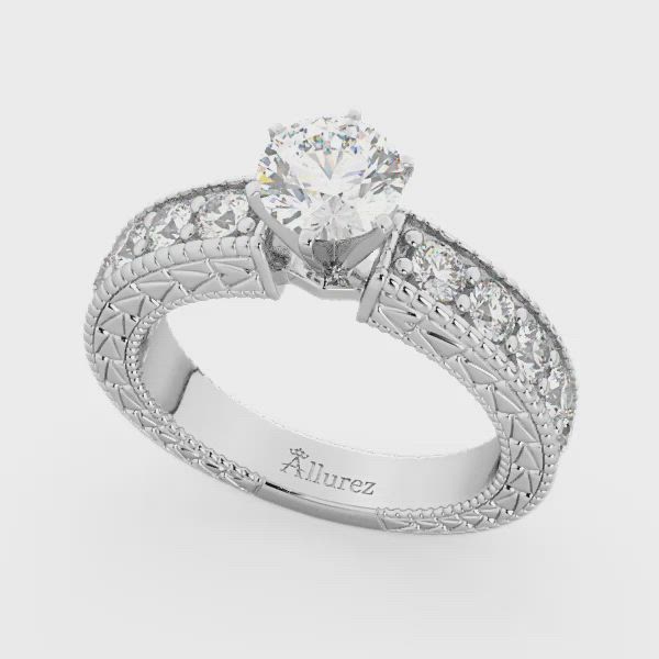 This may contain: a white gold engagement ring with an intricate design and round brilliant diamonds on the band