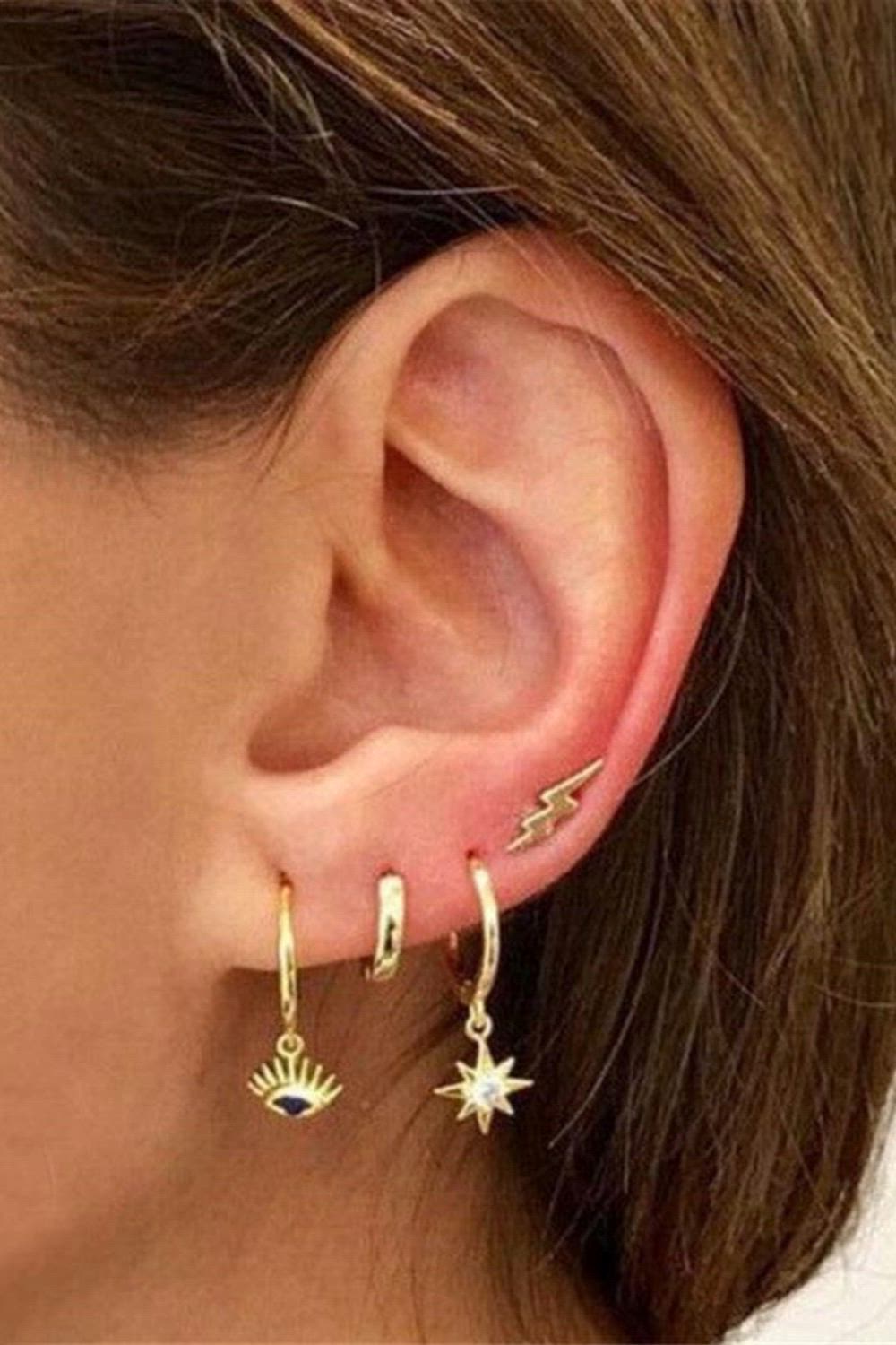 This contains: A woman wearing multiple ear piercings.