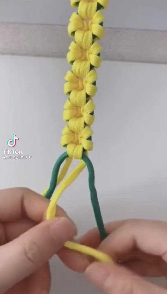 This may contain: two hands are holding yellow and green crocheted yarn with the ends facing each other