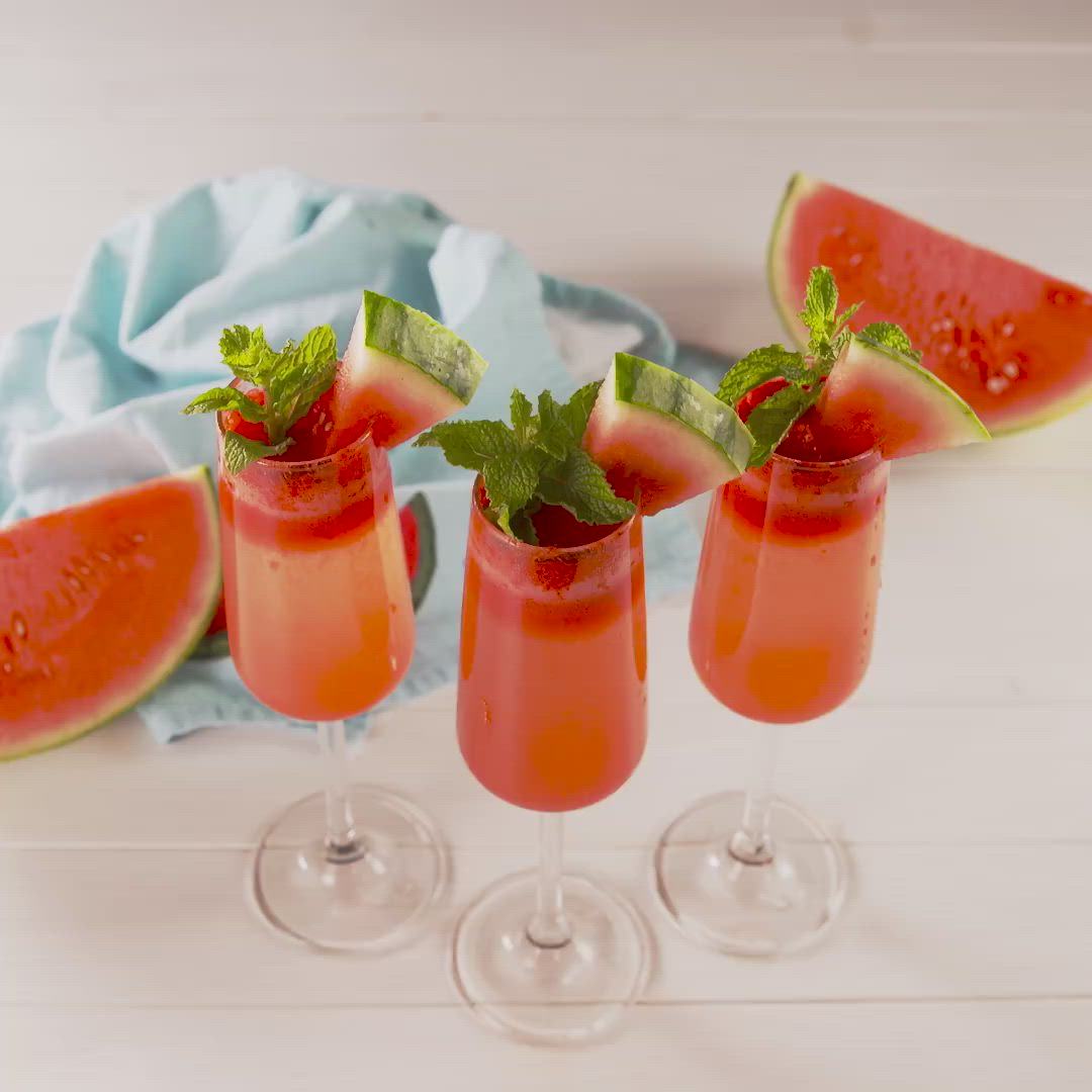 This may contain: three glasses filled with watermelon and mint garnish next to slices of watermelon