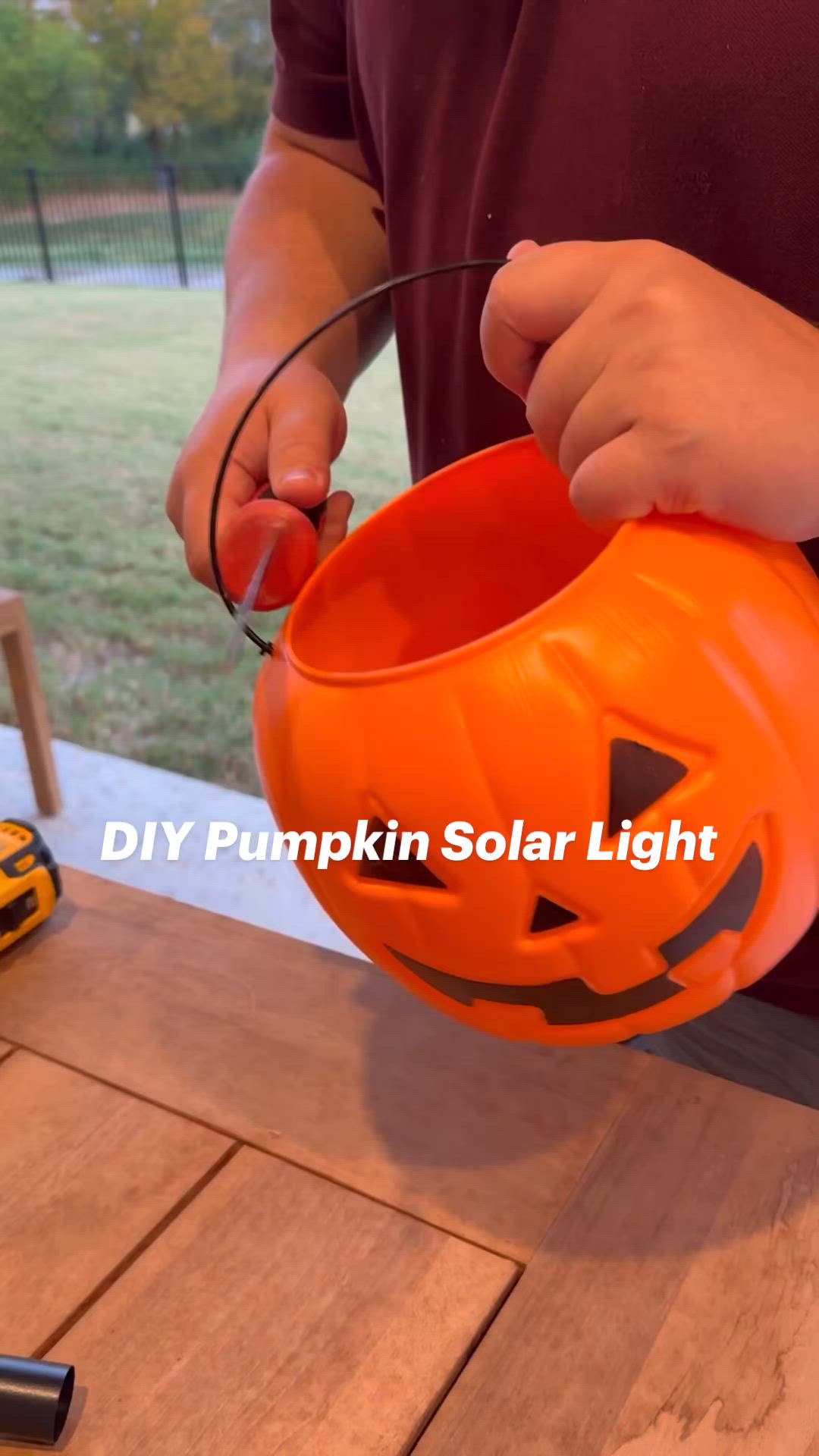 This may contain: a man is holding a pumpkin shaped bucket with wire in it and the words diy pumpkin solar light