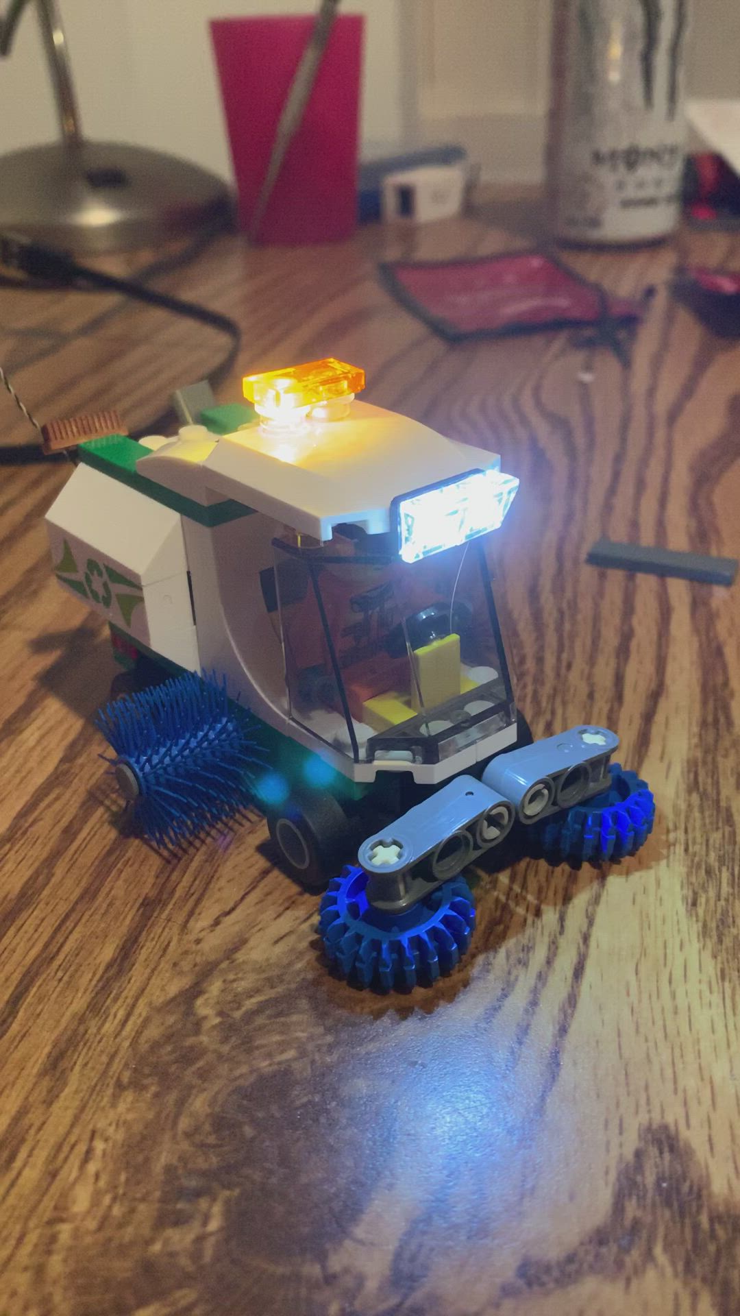 This may contain: a toy truck with lights on sitting on top of a wooden table next to a computer mouse