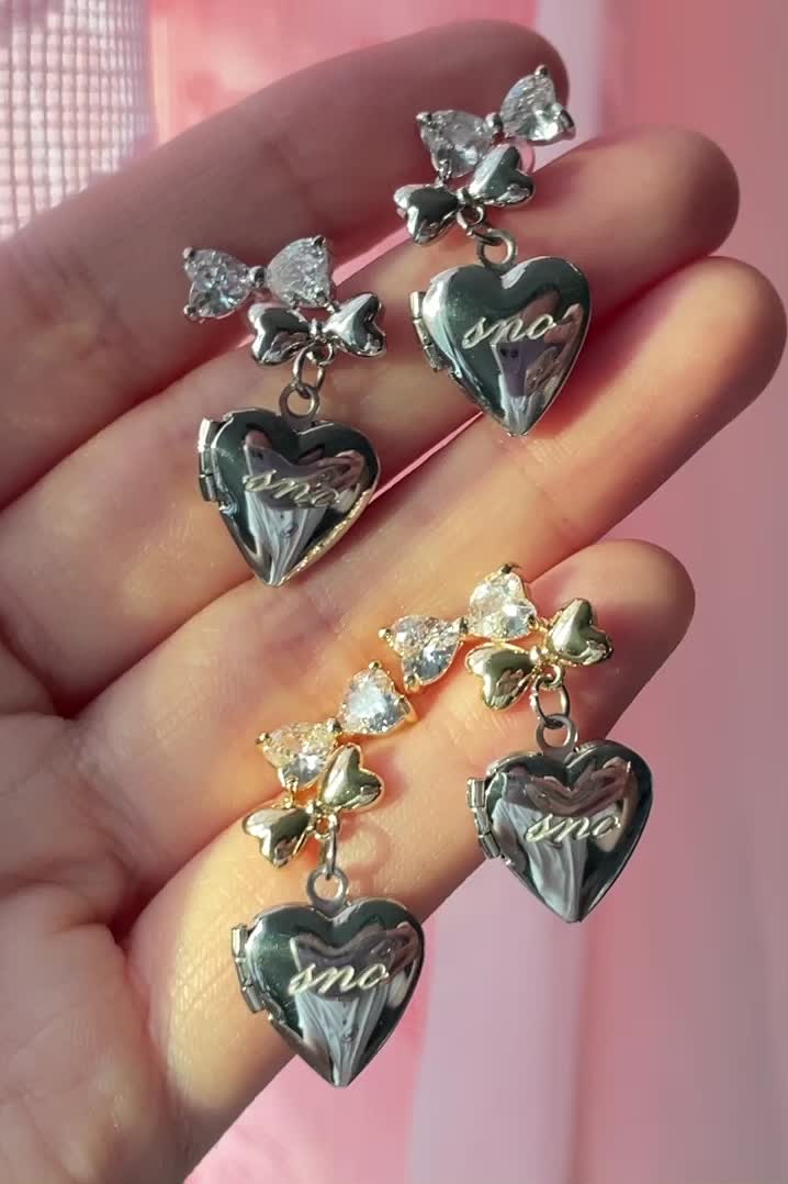 This contains an image of: Double Bow Locket Earrings By Feels Like Sno