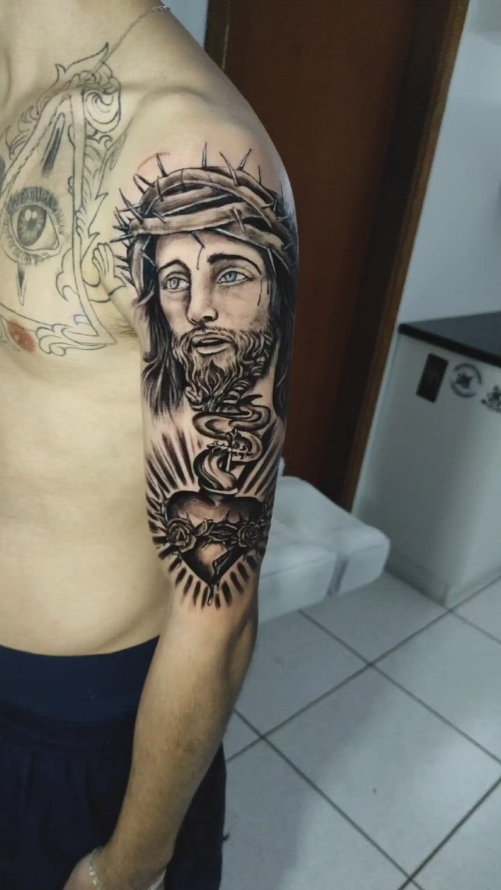 This contains an image of: Tattoo preto e cinza 🔥🔥 sagrado coração de Jesus.