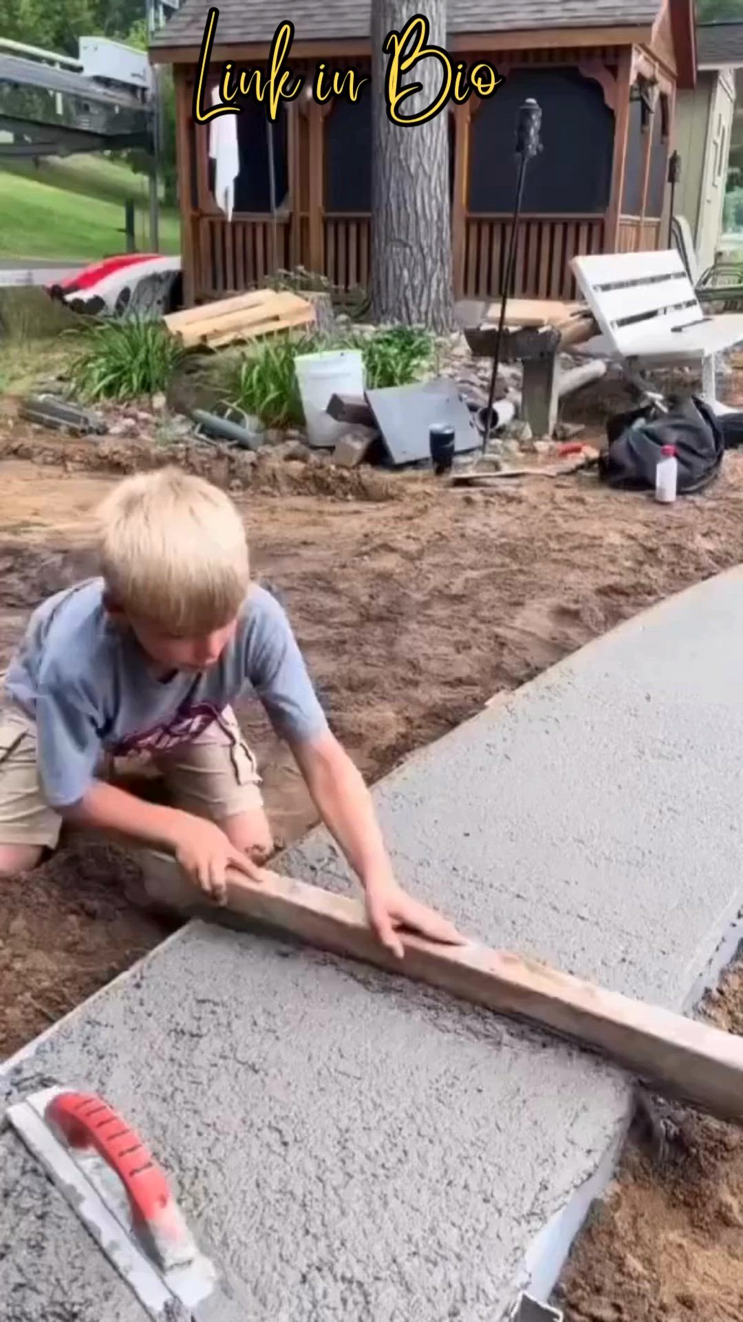 This may contain: a little boy that is standing on some kind of flooring board in the dirt