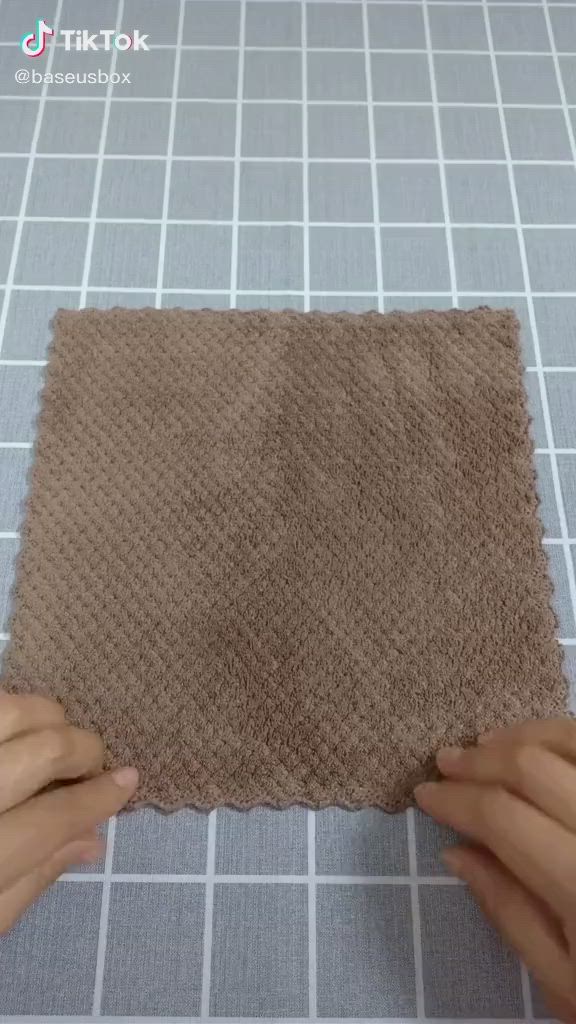 This may contain: someone is making a piece of cloth with their hands