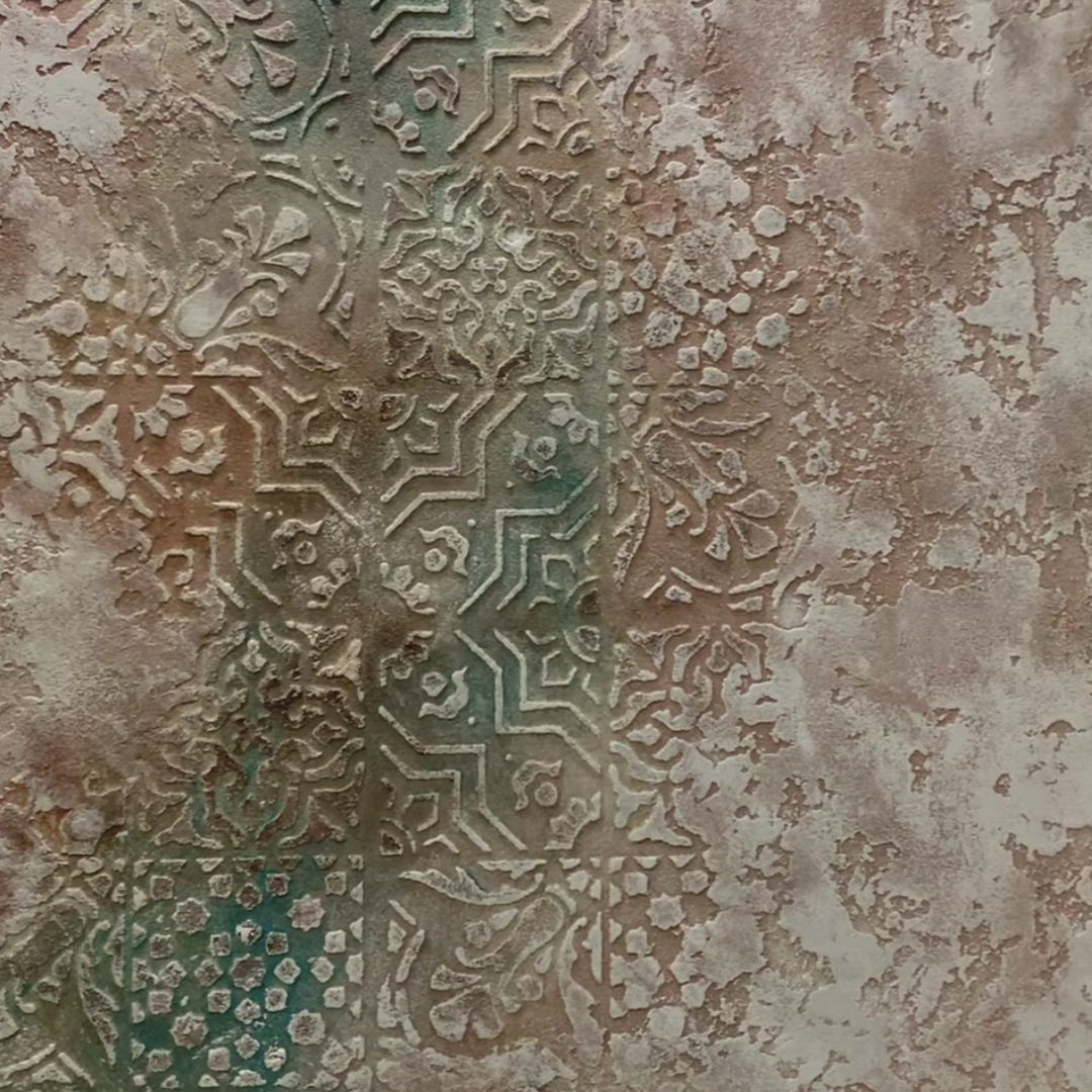 This may contain: an old wall with peeling paint and designs on it