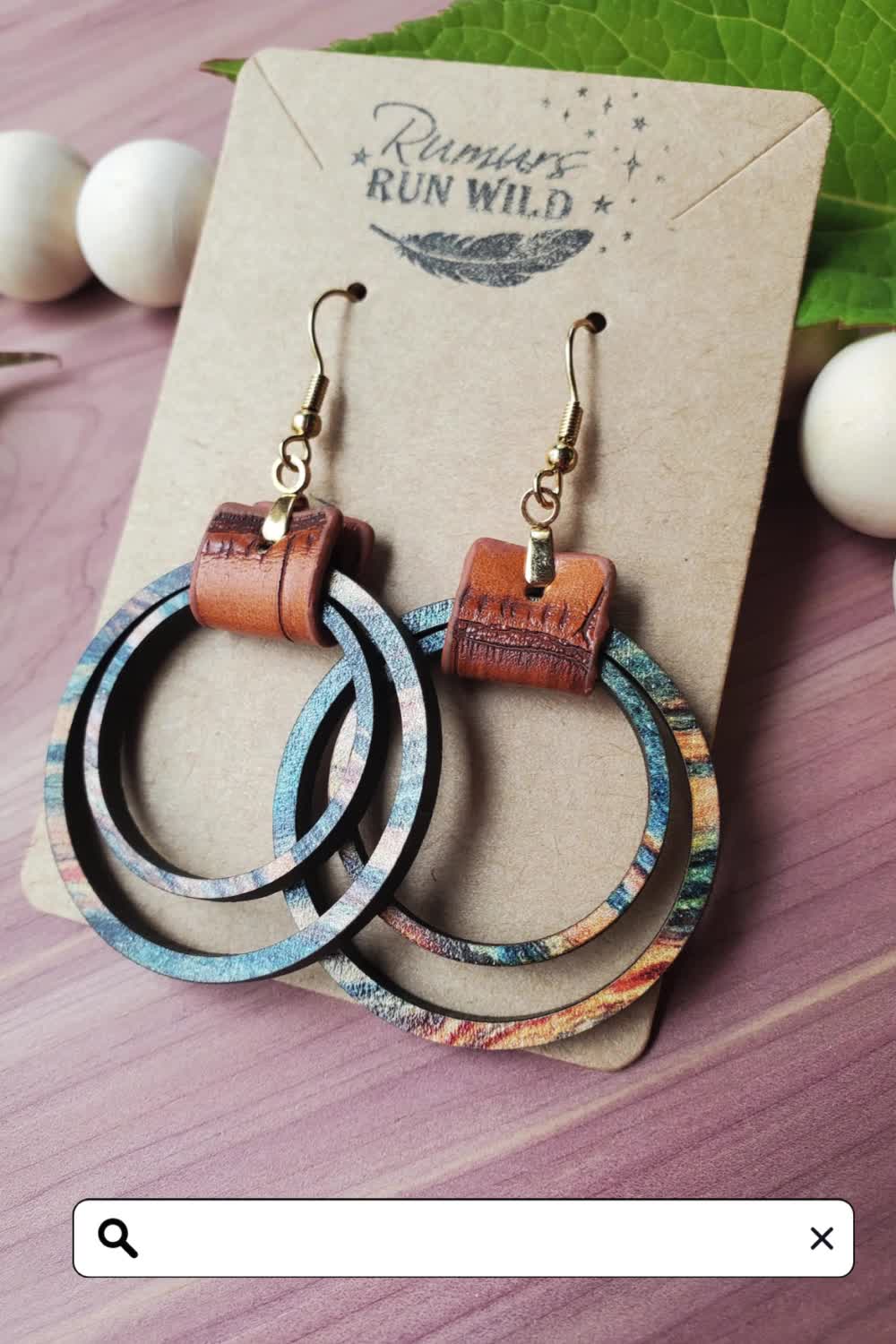 These wooden dangle earrings are a perfect gift for your best friend or a wonderful birthday gift for your girlfriend. The colorful wooden circles come in many different natural colors, with the main color being blue and having varying amounts of green, brown, orange, and yellow. They are paired with brown vegan leather and nickel-free, hypoallergenic stainless steel hardware.