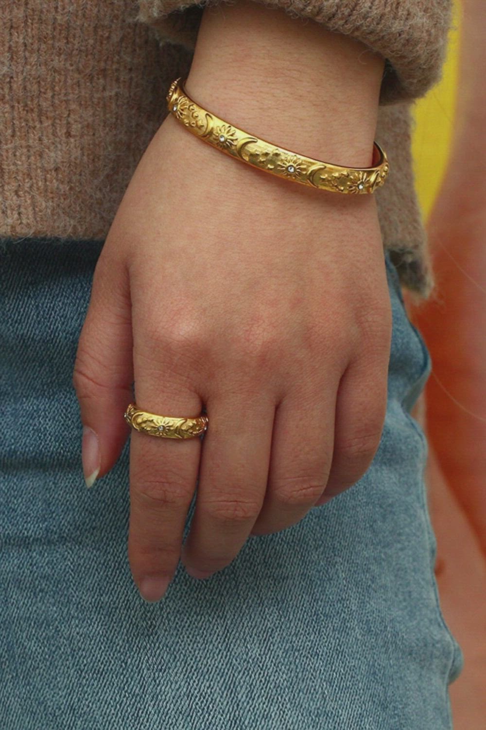 This contains: A woman wearing a gold celestial bracelet.