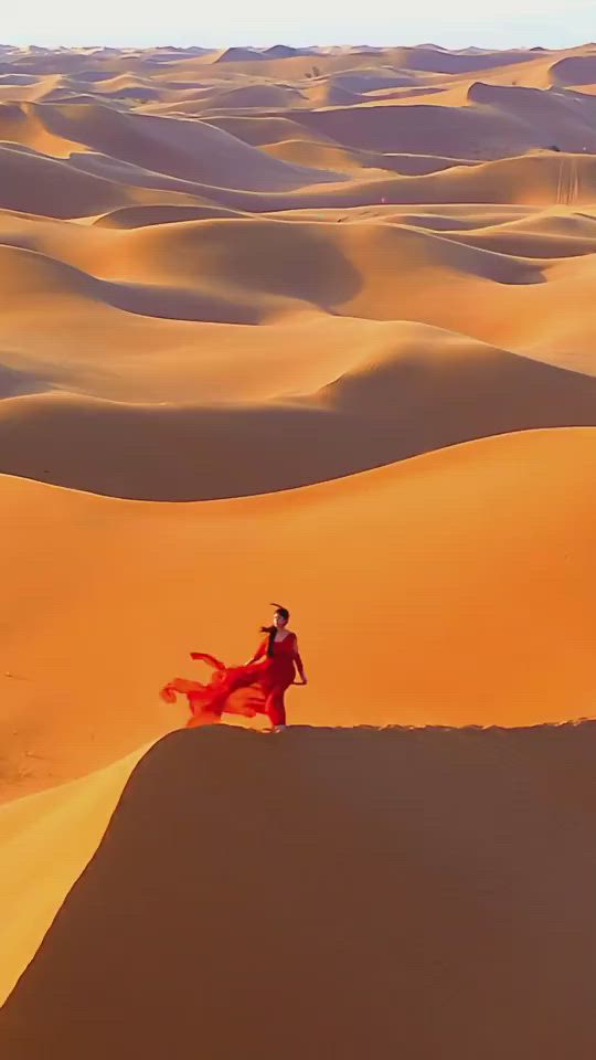 This may contain: a man in a red suit is walking through the desert