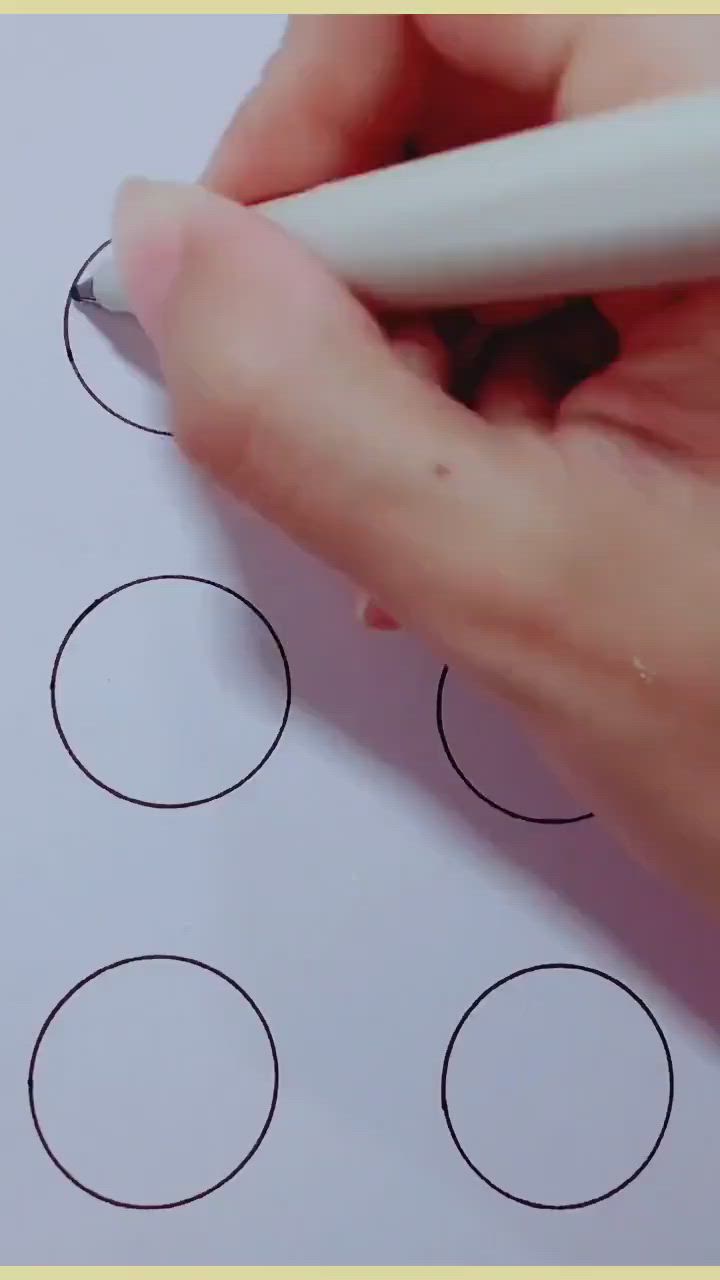 This may contain: someone is drawing circles with a marker on paper that says smiley face and four circles