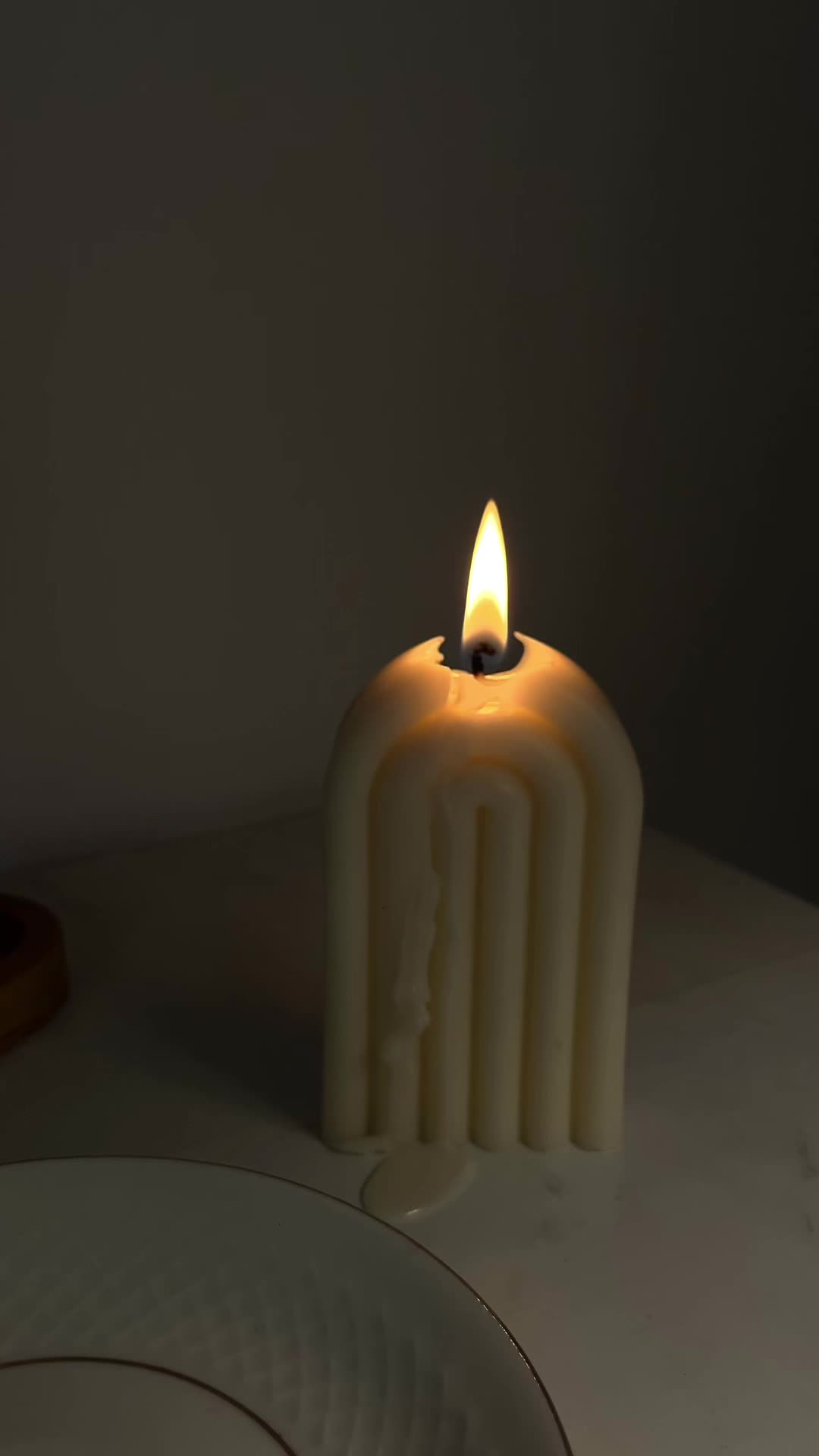 This may contain: a lit candle sitting on top of a white plate