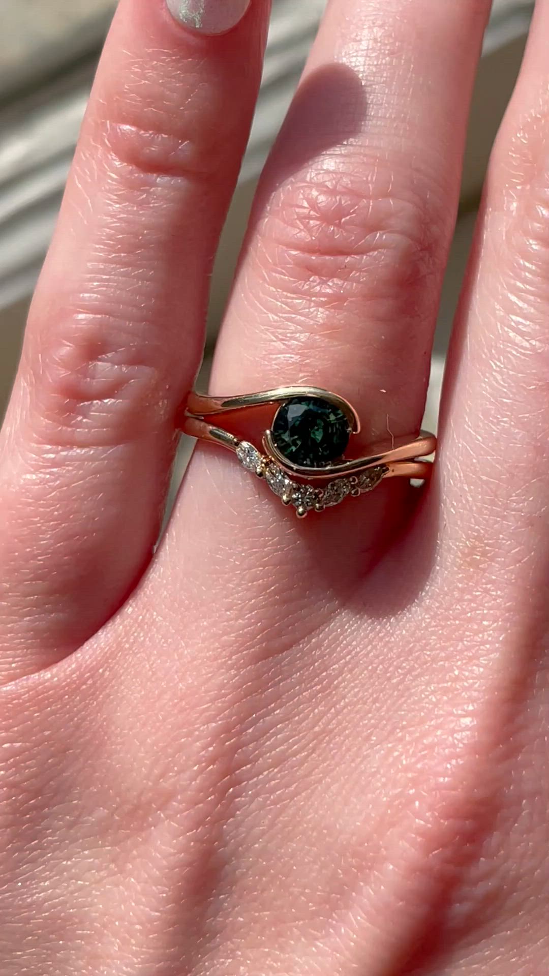 This may contain: a woman's hand with a ring on it that has a green stone in the middle