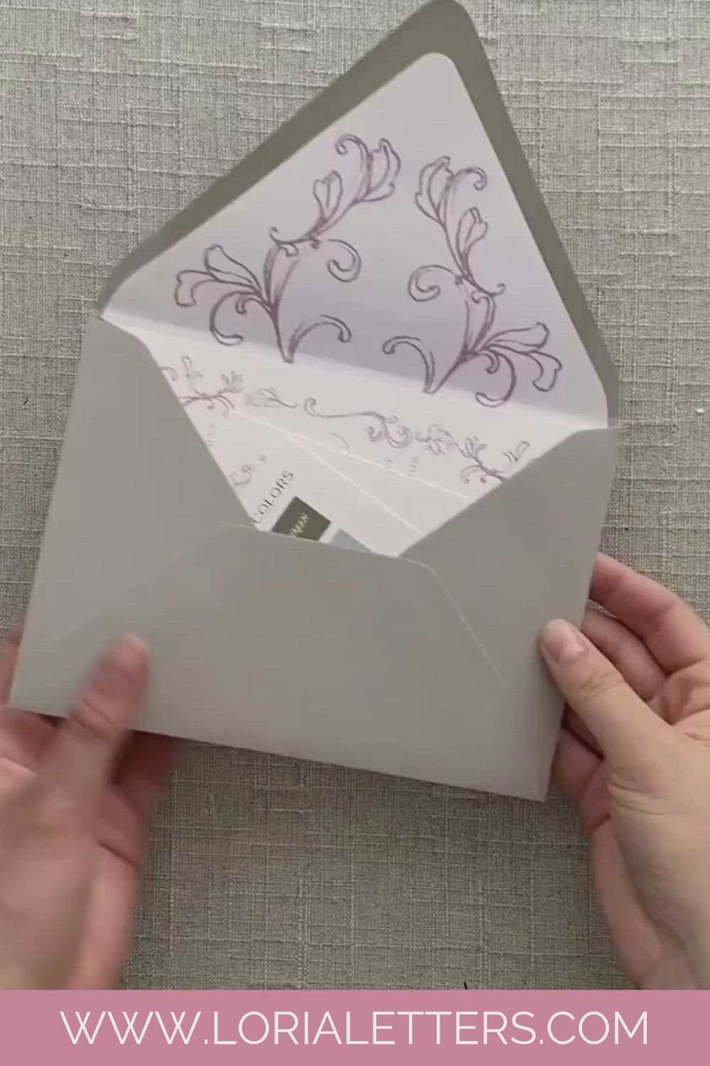 This may contain: someone is opening an envelope with the inside flap open and it has floral designs on it