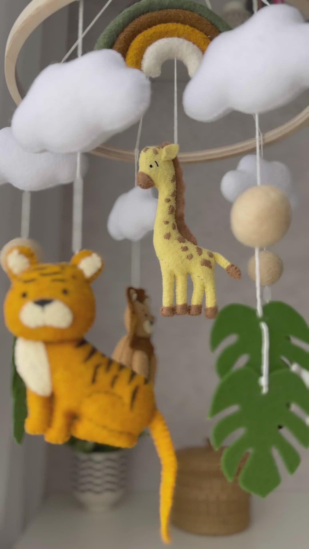 This contains: This is a safari baby mobile in a neutral color palette featuring a tiger, giraffe, zebra, lion, and rainbow.

Jungle mobile nursery will decorate your nursery and encourage your baby's development. You can hang it above the crib or changing table to create a bright and joyful atmosphere in your baby's room. Also this cot mobile is a spectacular jungle-inspired baby shower gift or kids birthday party.