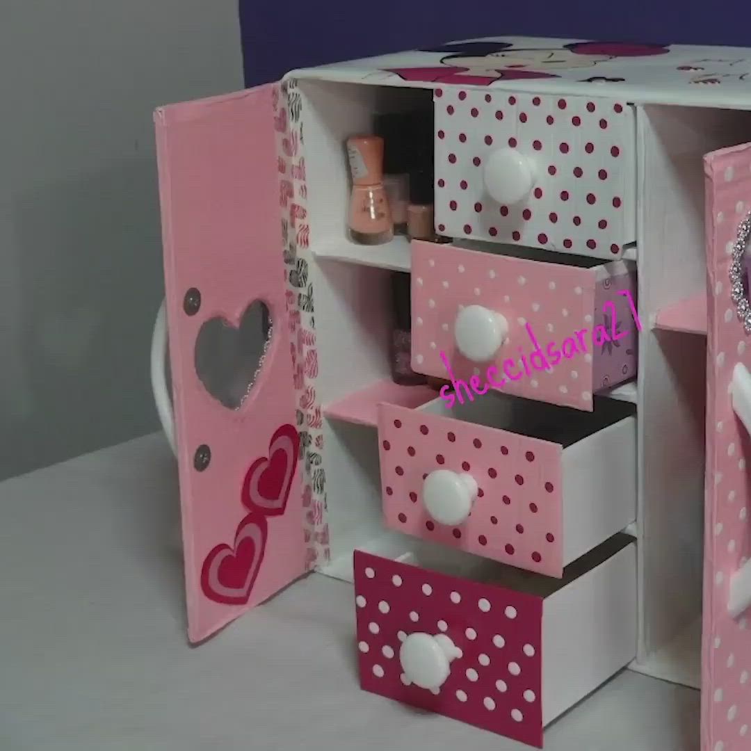 This may contain: a pink and white doll house with polka dots on the doors, drawers and shelves