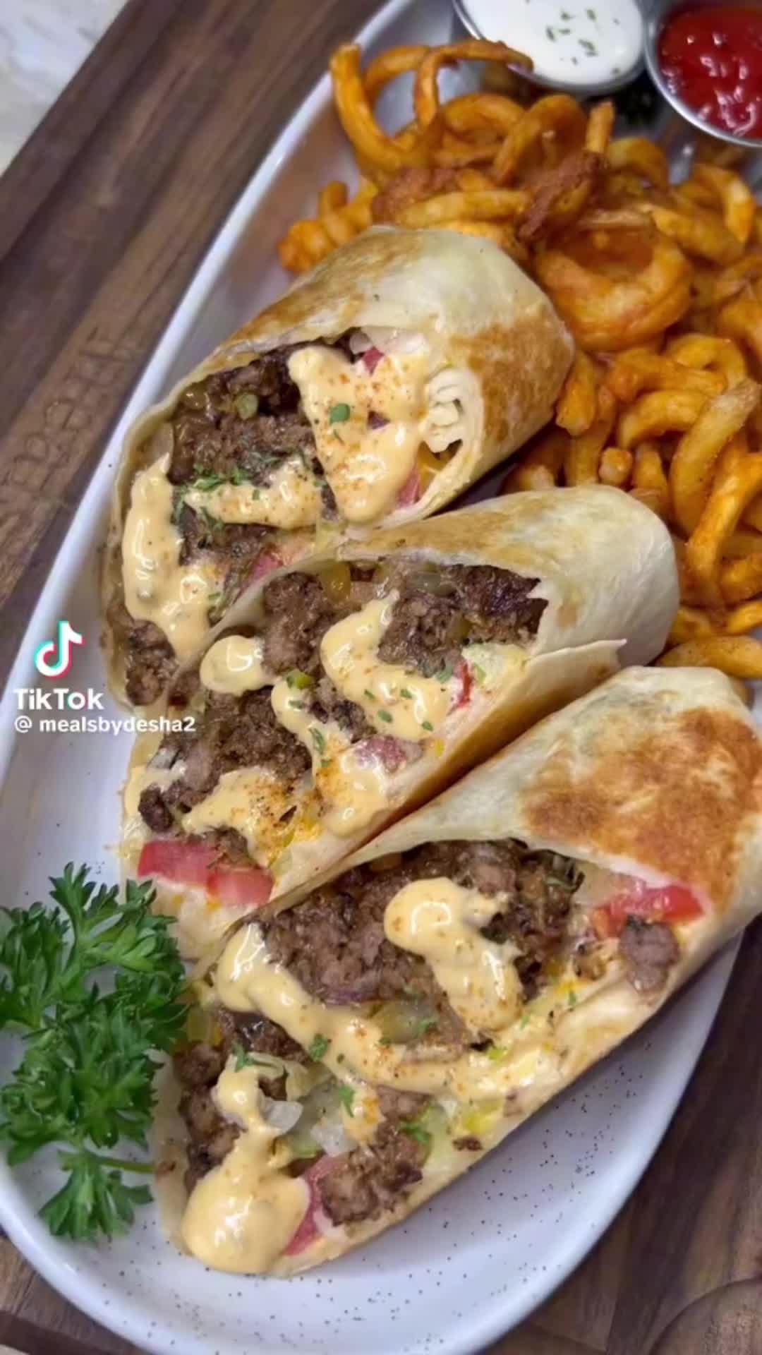 This may contain: two burritos on a plate with fries and ketchup