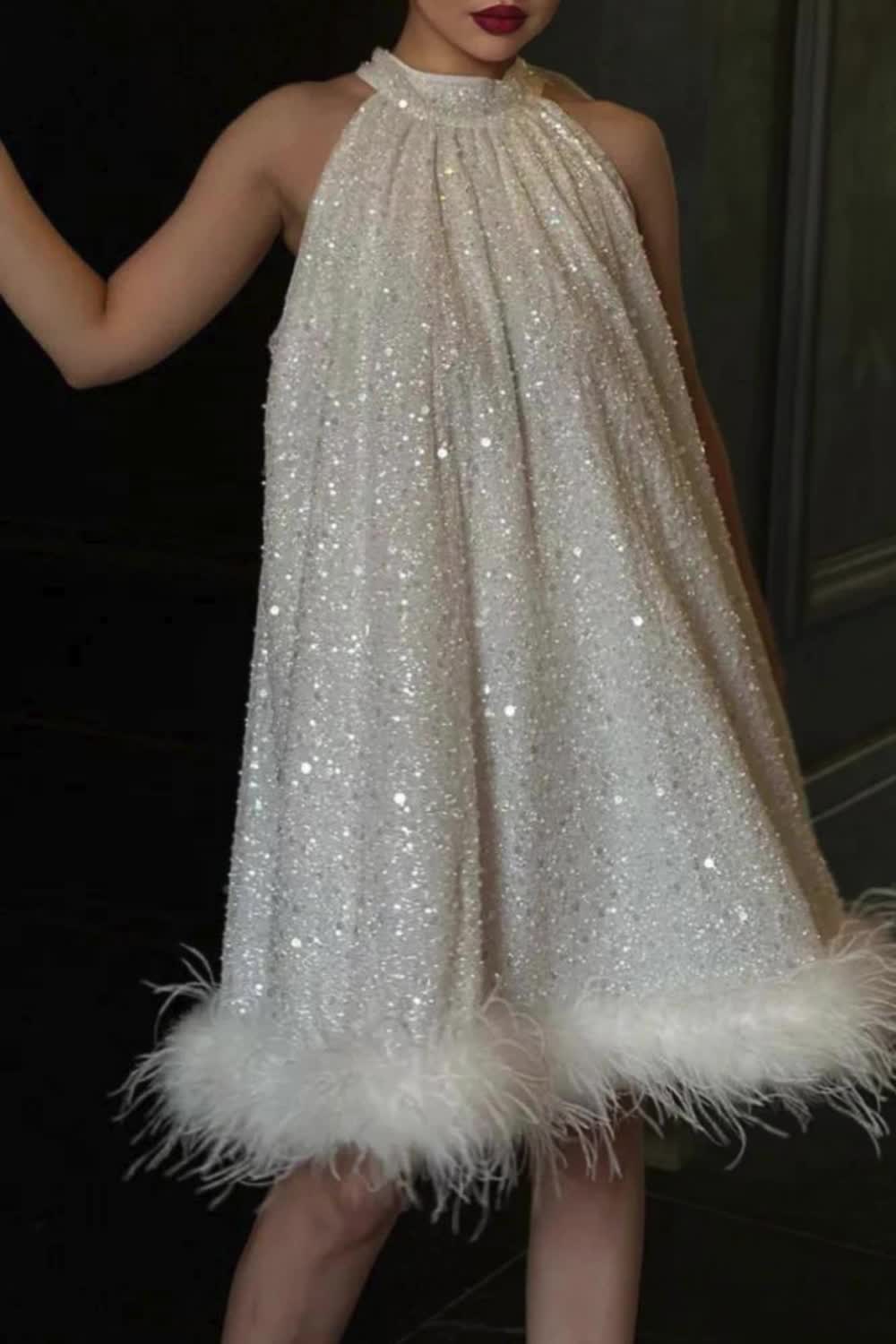 This evening dress epitomizes elegance with its solid sequins, delicate feathers, and a charming bow halter neckline. It exudes sophistication and glamour, making it the perfect choice for formal occasions. With its exquisite details, this dress is sure to captivate attention and leave a lasting impression.