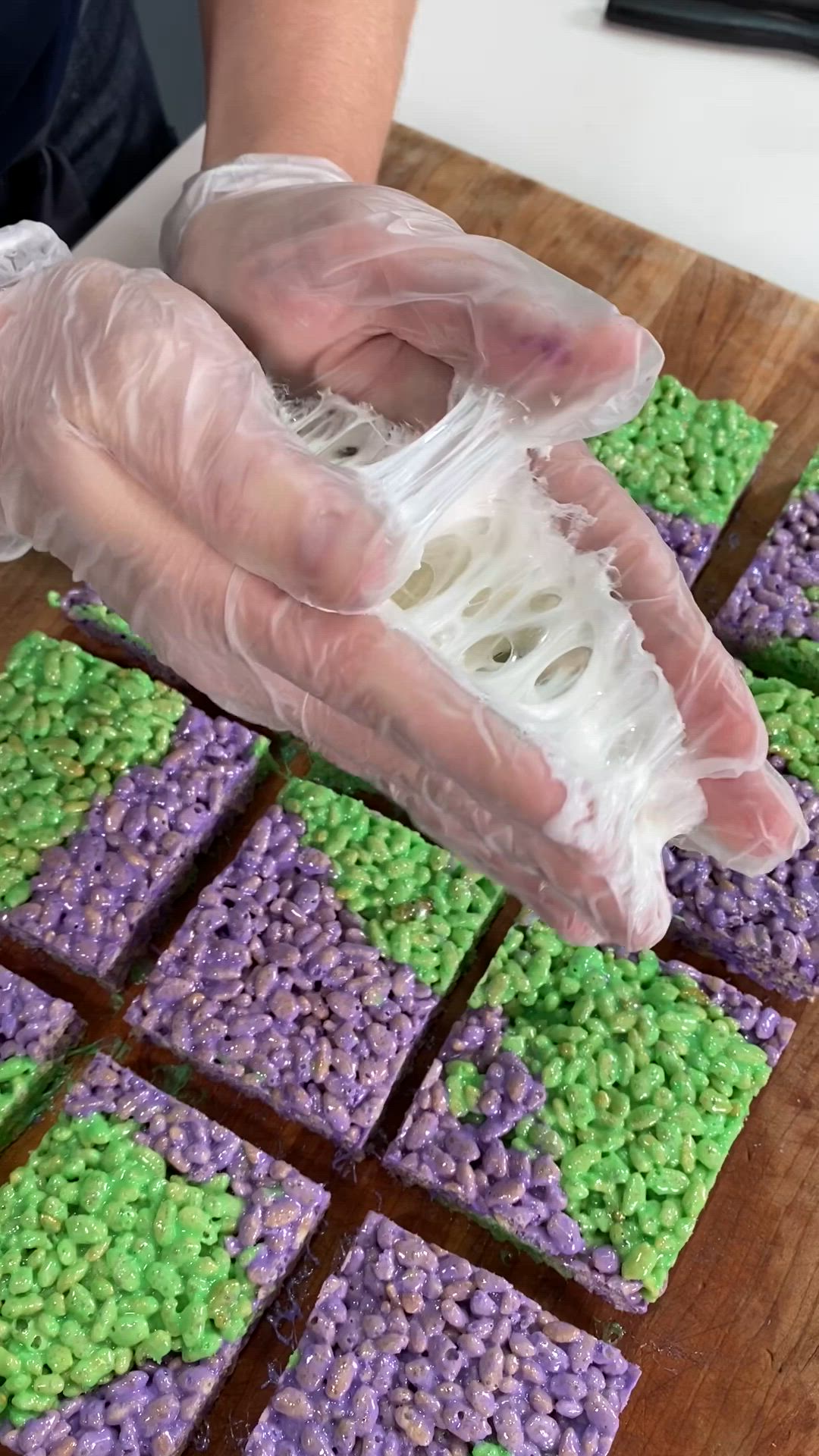 This may contain: purple and green treats are on a wooden cutting board with white string wrapped around them