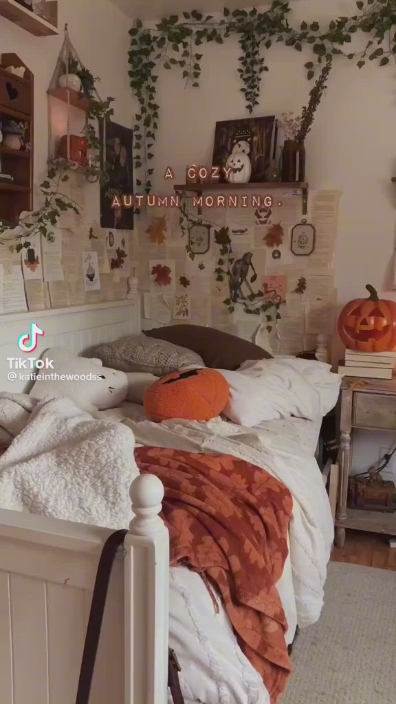 This may contain: a bedroom decorated for halloween with pumpkins on the bed and ivy growing on the wall