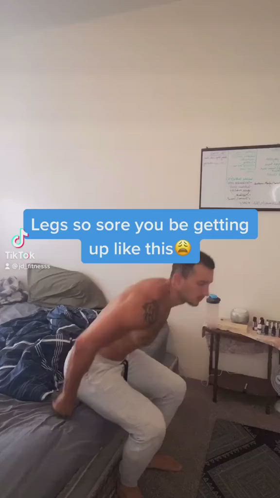 This may contain: a man is sitting on his bed and looking at the camera with an ad above him that reads, health and fitness legs so sore you're getting up like this