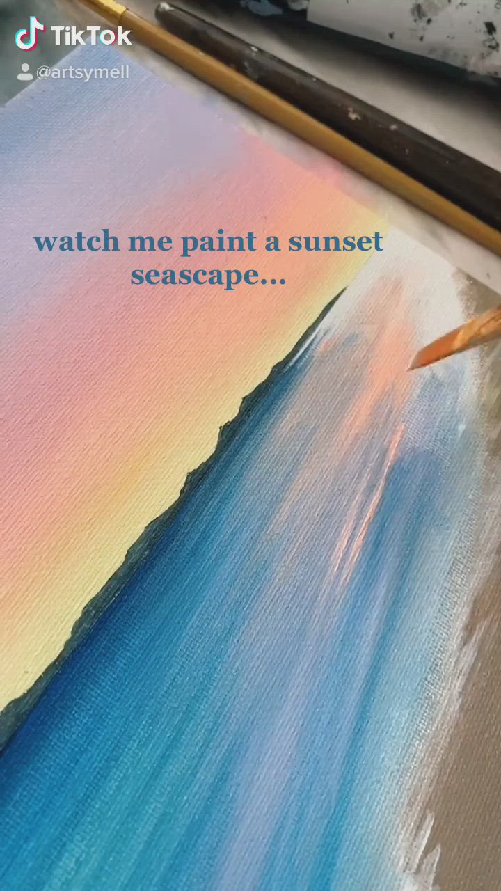 This may contain: someone is painting a sunset scene with watercolors on the paper and using a brush