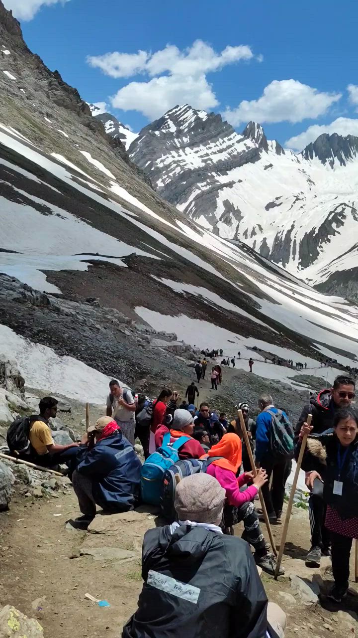 This may contain: a group of people standing on top of a snow covered mountain