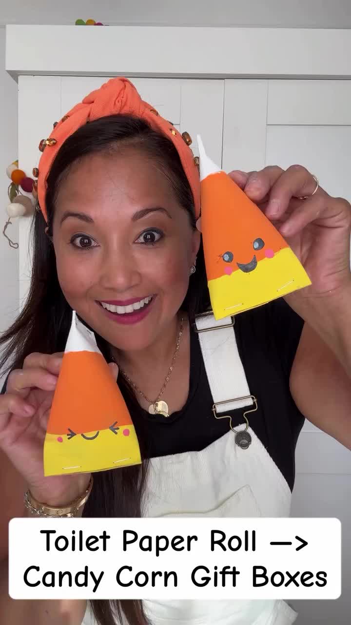 This may contain: two candy cones with faces on them sitting in front of a pumpkin shaped cake stand