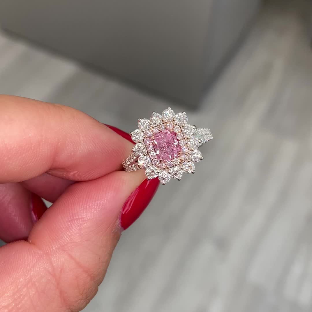 This contains: Fancy Purplish Pink Radiant Cut Diamond Ring, with a vibrant natural pink center diamond surrounded ny side white diamonds. a magnificent and unique pink diamond engagement ring or a gift for a very special occasion.