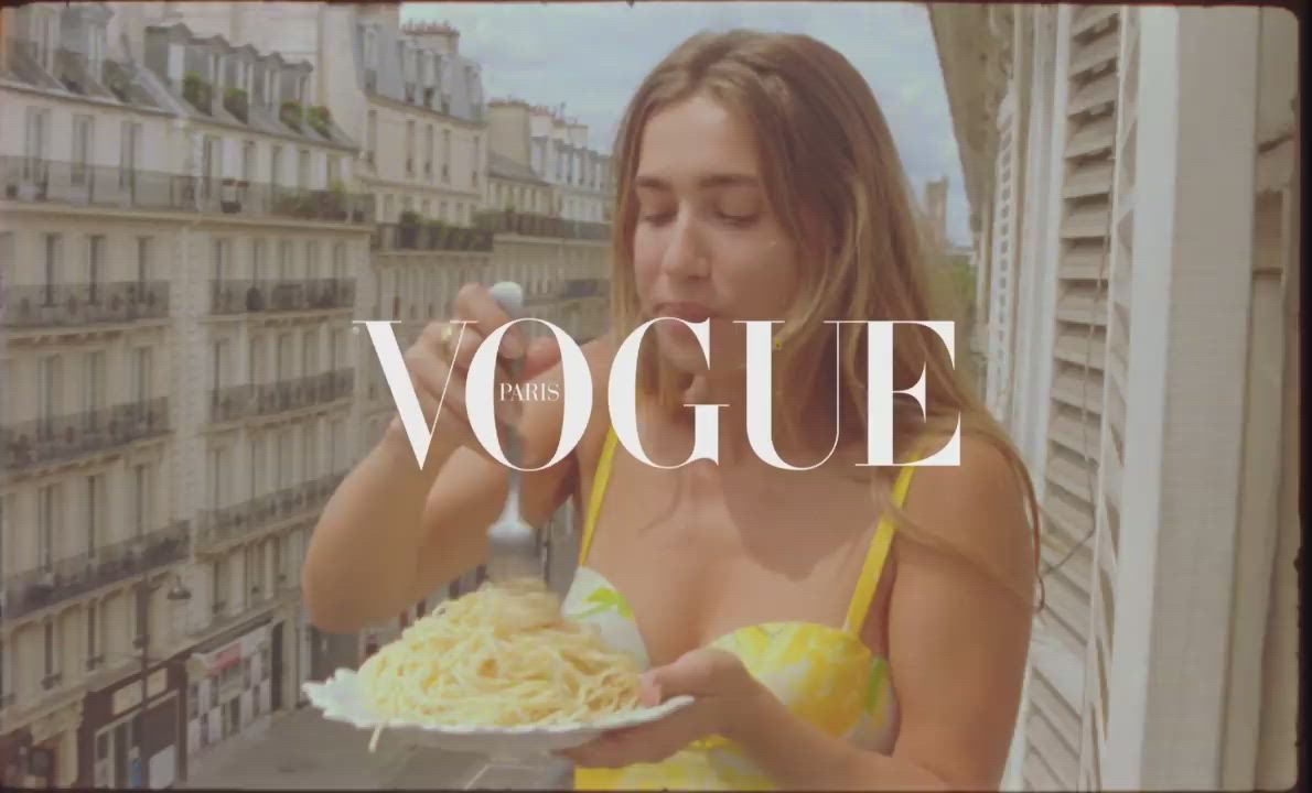 This may contain: a woman holding a plate of food with the words vogge in front of her