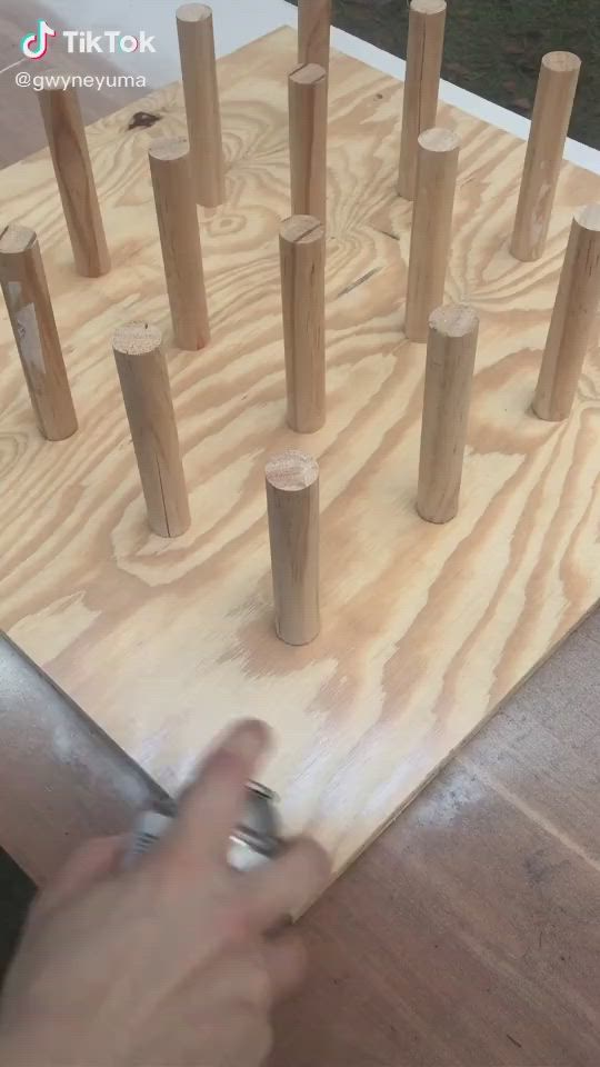 This may contain: a person is playing with wooden pegs on the table and it looks like they are making something out of wood