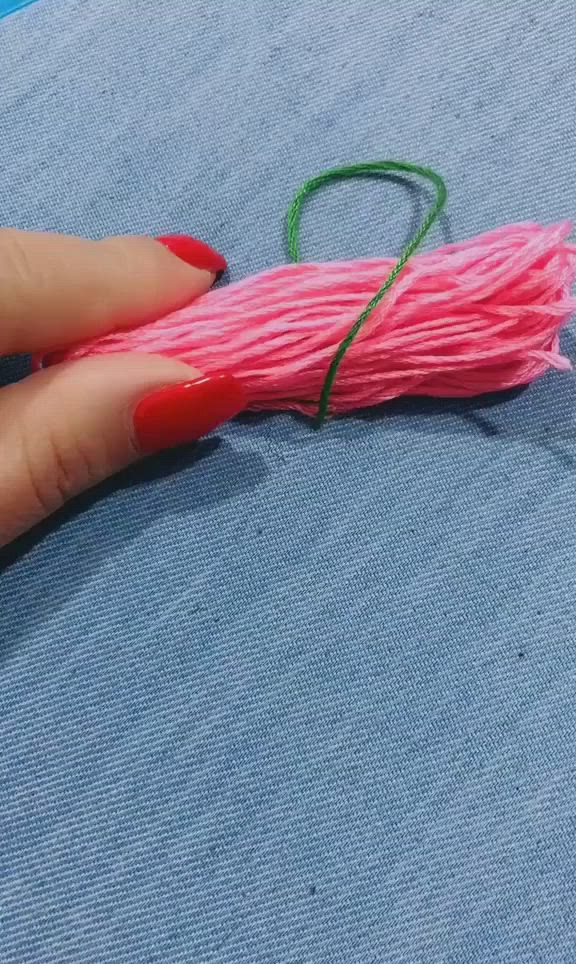 This may contain: someone is sewing something with pink yarn