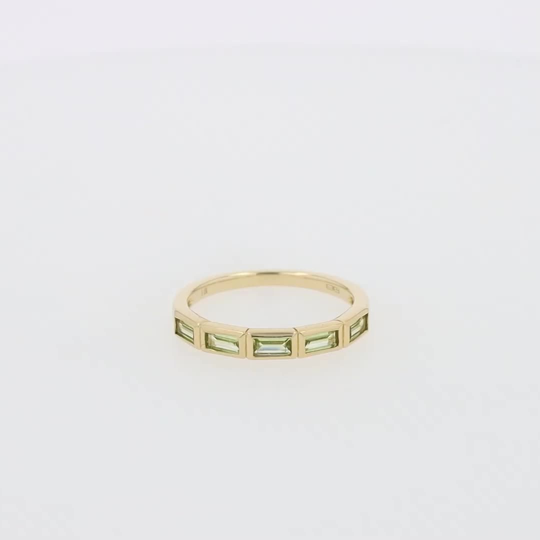 This may contain: a yellow gold ring with three baguettes