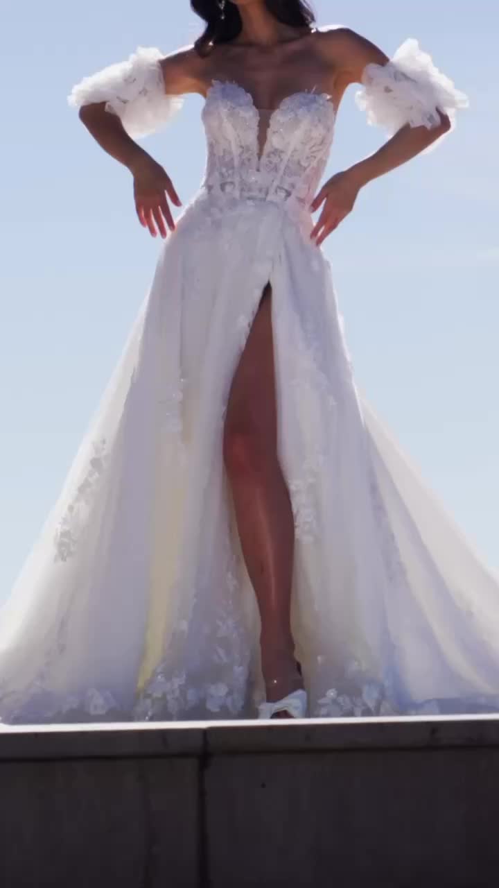 This may contain: a woman in a white wedding dress posing for the camera with her arms outstretched and legs spread out