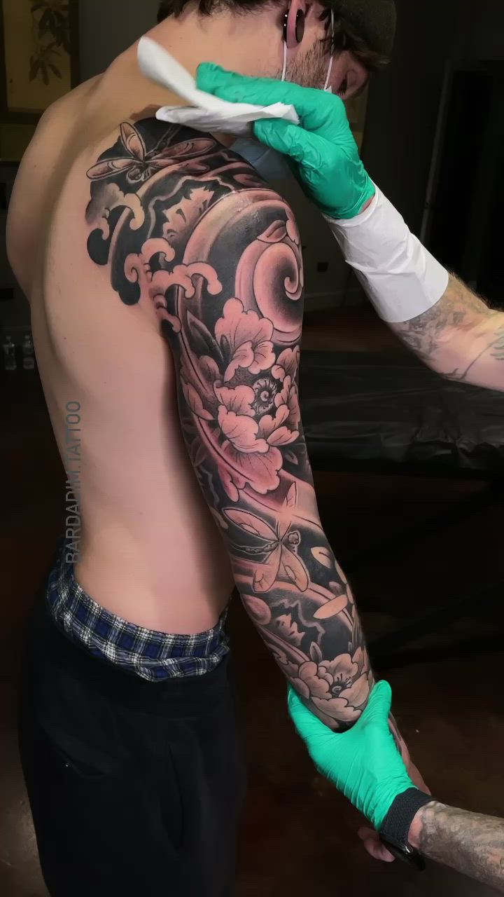 This contains: Black and gray Japanese tattoo. Full sleeve tattoo. Peony tattoo