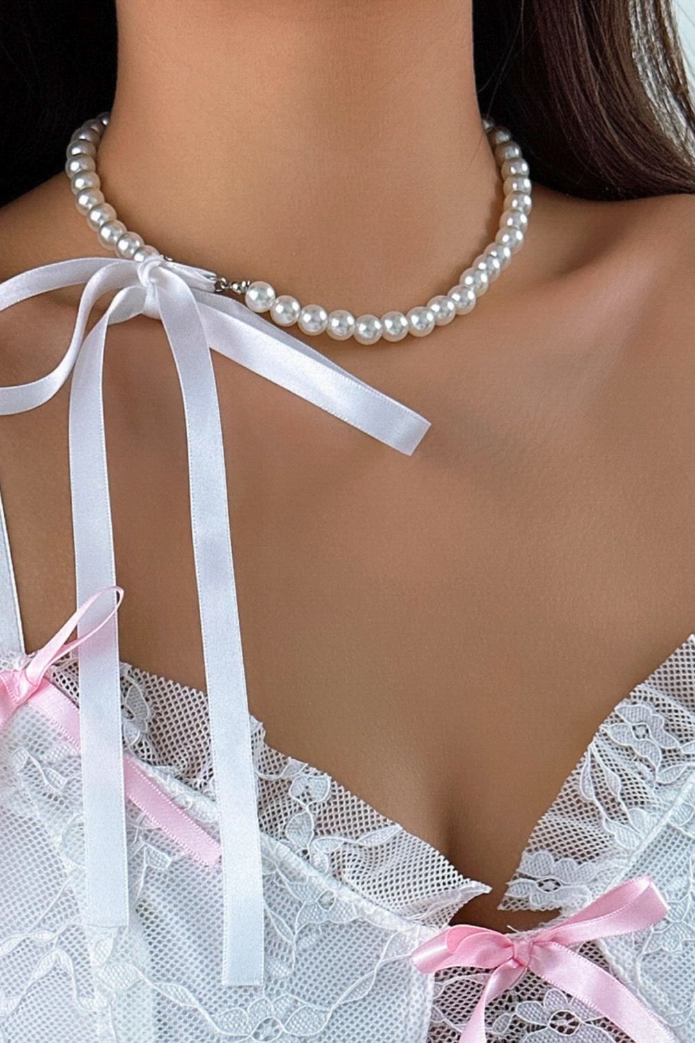 This contains: Introducing our Vintage Imitation-Pearl Heart Necklace, the perfect accessory for your wedding or special event. Made with high-quality materials, this necklace features an OT Buckle Pendant adorned with beautiful imitation pearls. Get ready to turn heads and make a statement with this elegant and timeless piece of jewelry.