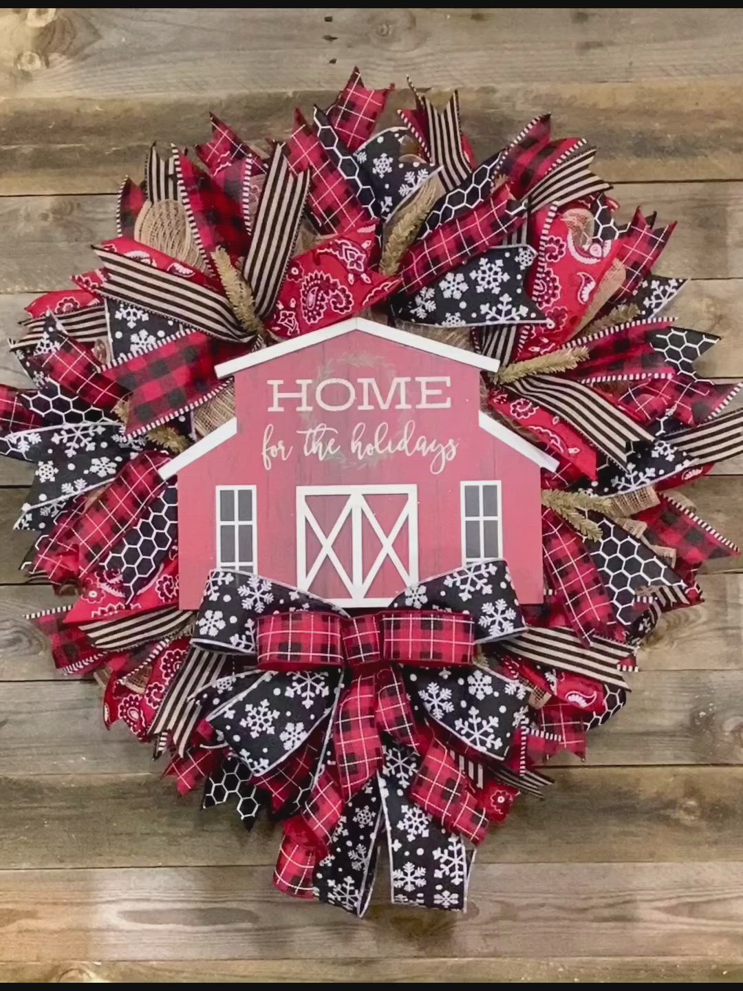 This may contain: a red and black wreath with the words home for the holidays written in white on it