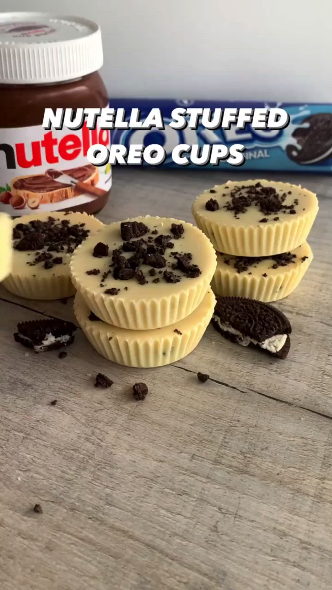 This may contain: three cupcakes sitting on top of a table next to a jar of nutella stuffed oreo cups