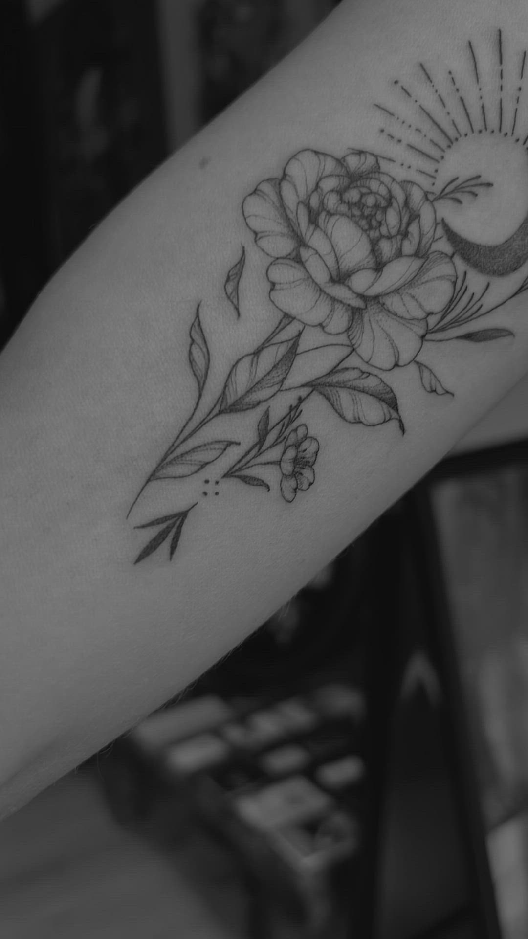 This may contain: a black and white photo of a flower on the arm