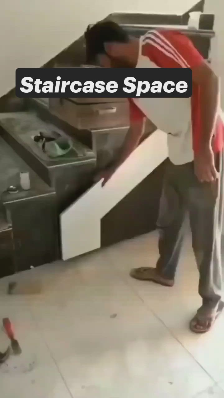 This may contain: a man standing in front of a stack of drawers with the words staircase space on it