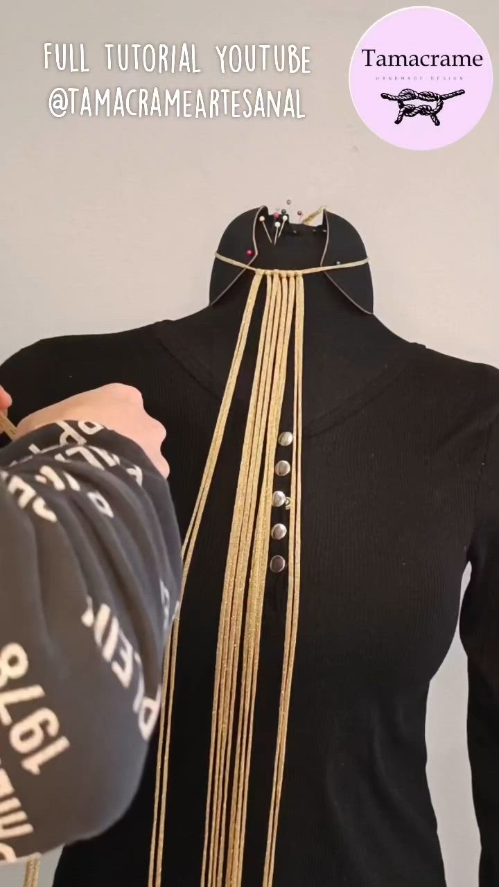 This may contain: a mannequin wearing a black shirt with gold chains