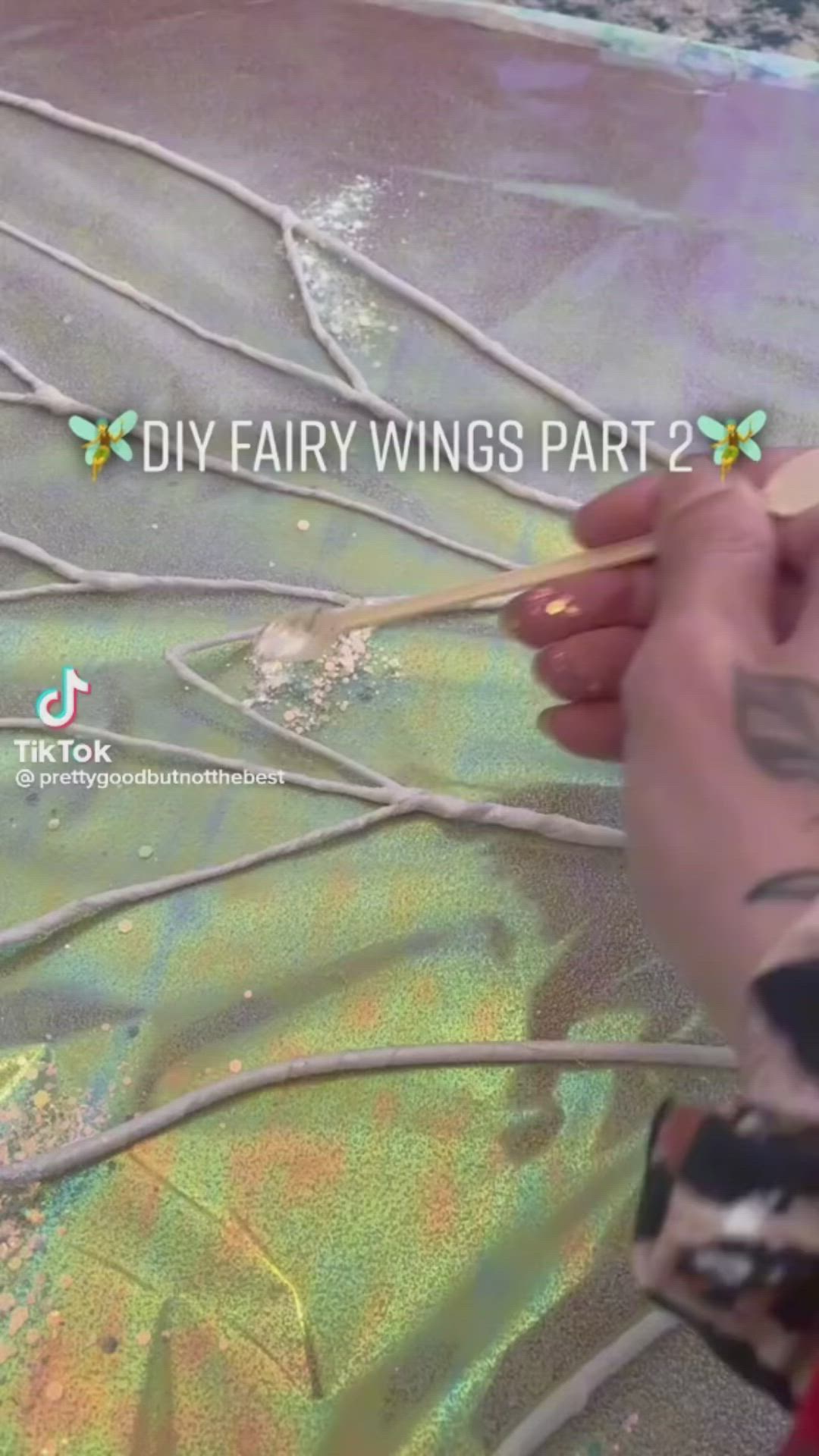 This may contain: someone is painting the floor with metallic paint and writing on it that says diy fairy wings part 2