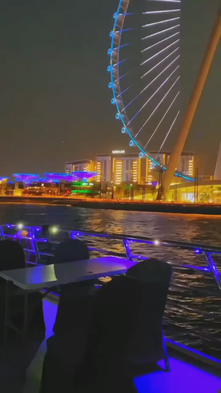 This may contain: the ferris wheel is lit up at night