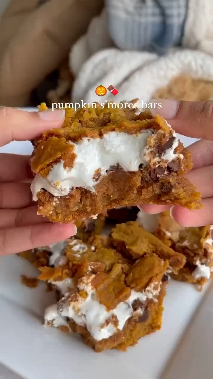 This may contain: two hands are holding up some desserts on a white plate with the words pumpkin's more bars in front of them