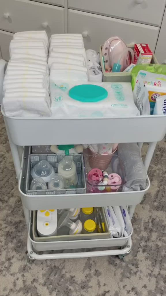 This may contain: a baby changing table with various items in it and someone's hand reaching for the diaper