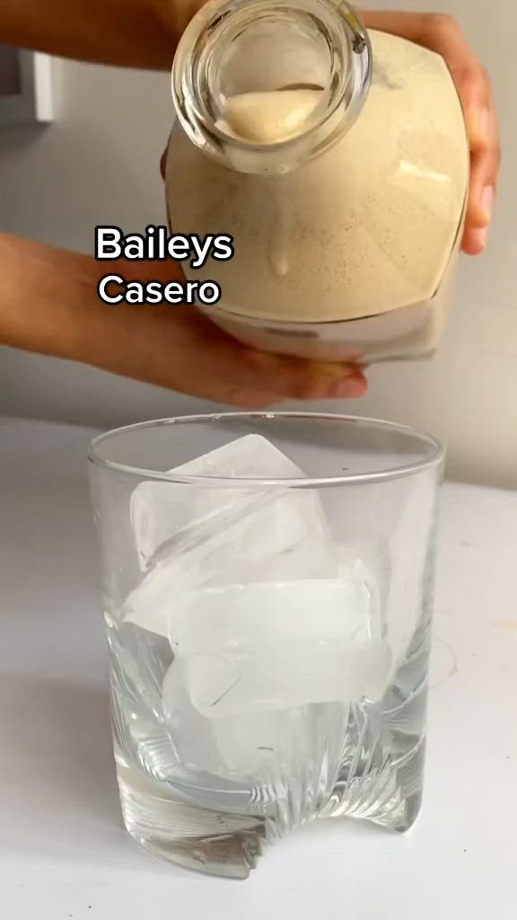 This may contain: someone is pouring ice into a glass with something in it and the words bailey's cassero written below