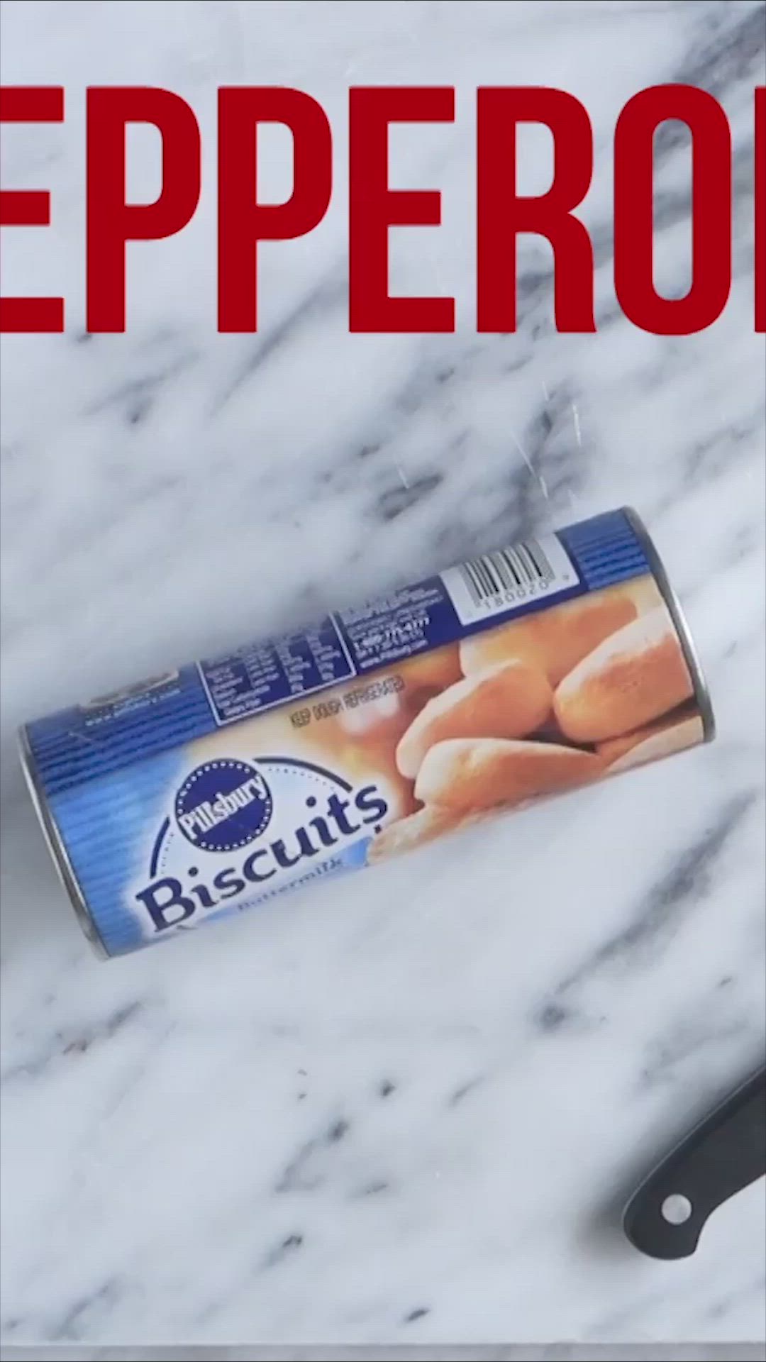 This may contain: a can of biscuits sitting on top of a counter next to a knife