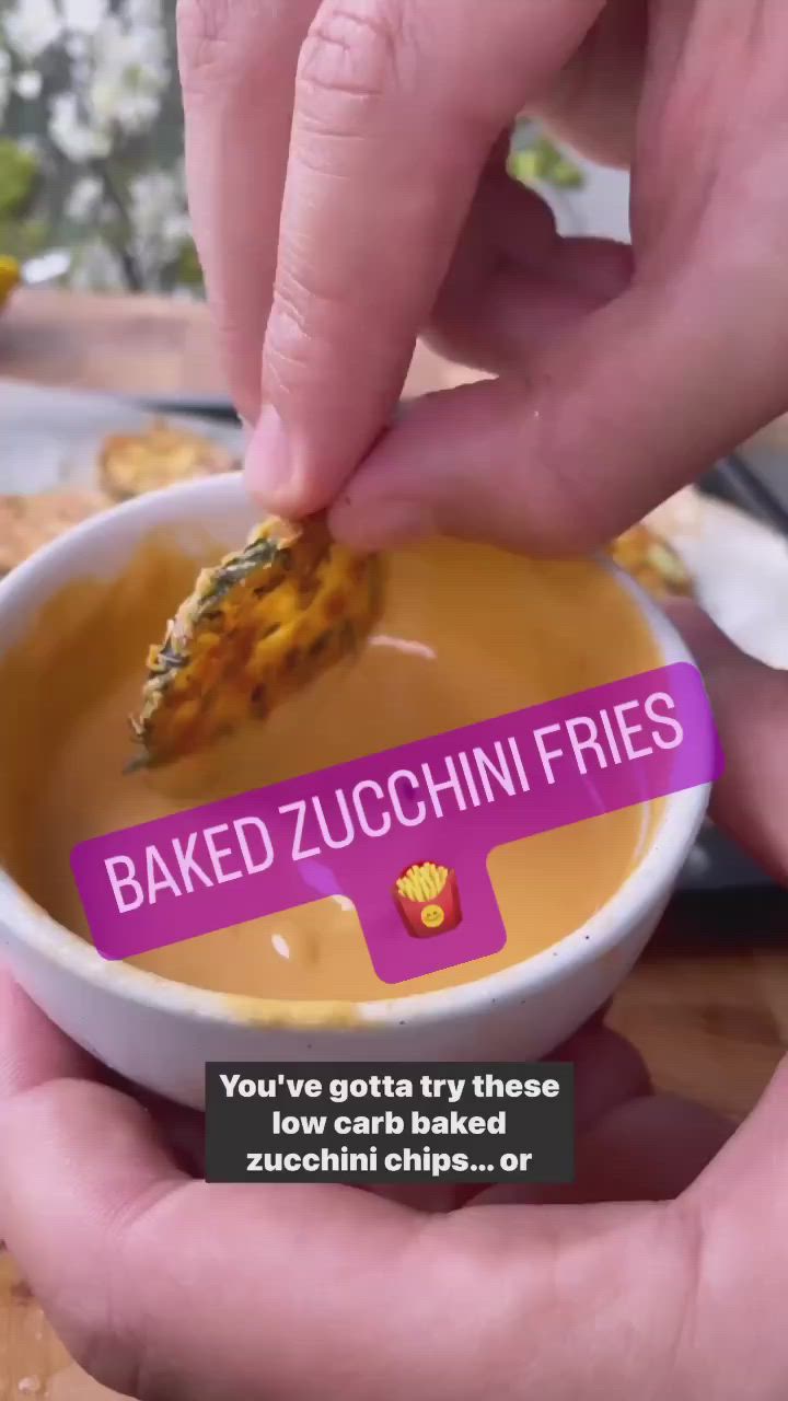 This may contain: someone is dipping some kind of food in a bowl with the words baked zucchini fries on it